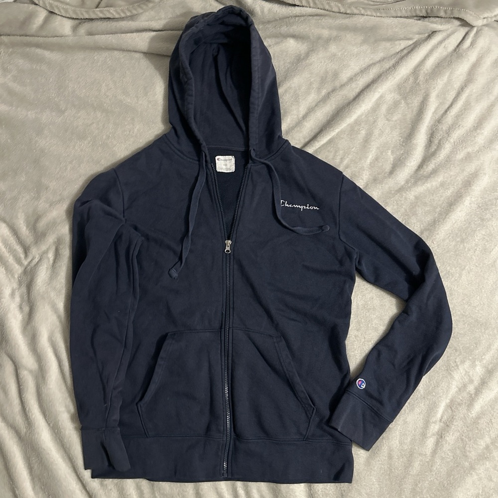 This is a Champion zip up sweater in the color navy blue. This is a size MEDIUM